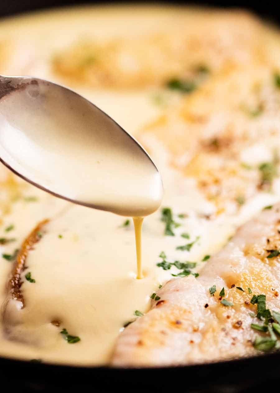 Close up of drizzling white wine sauce