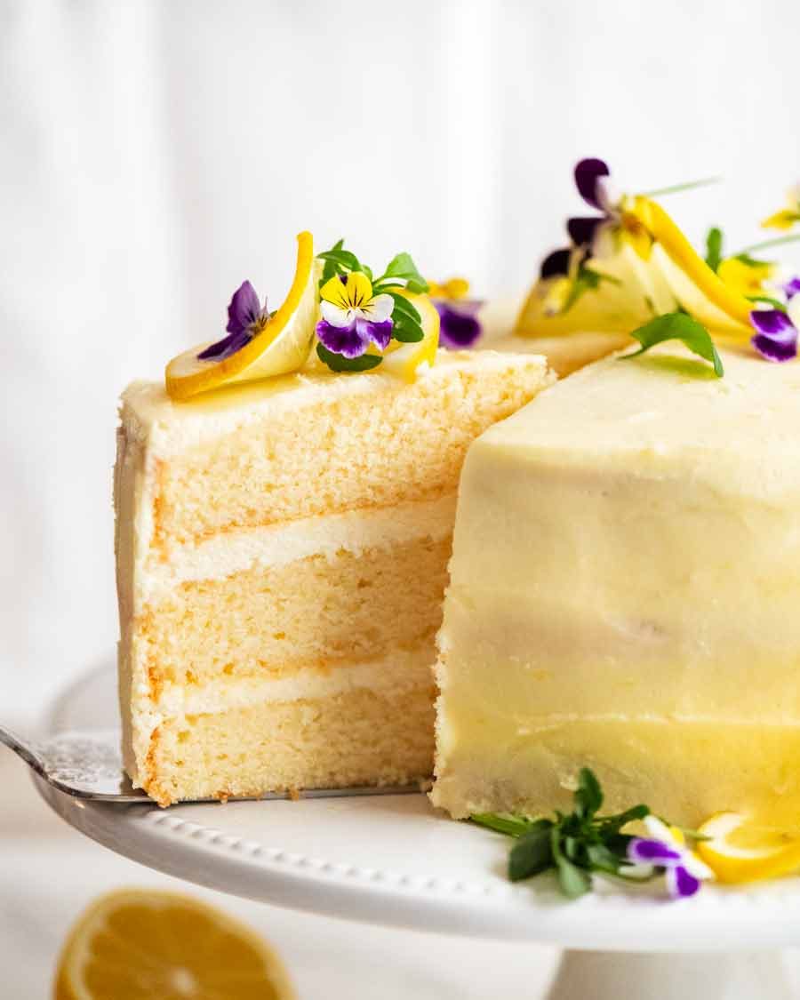 Pulling out a slice of Lemon Cake with Fluffy Lemon Frosting