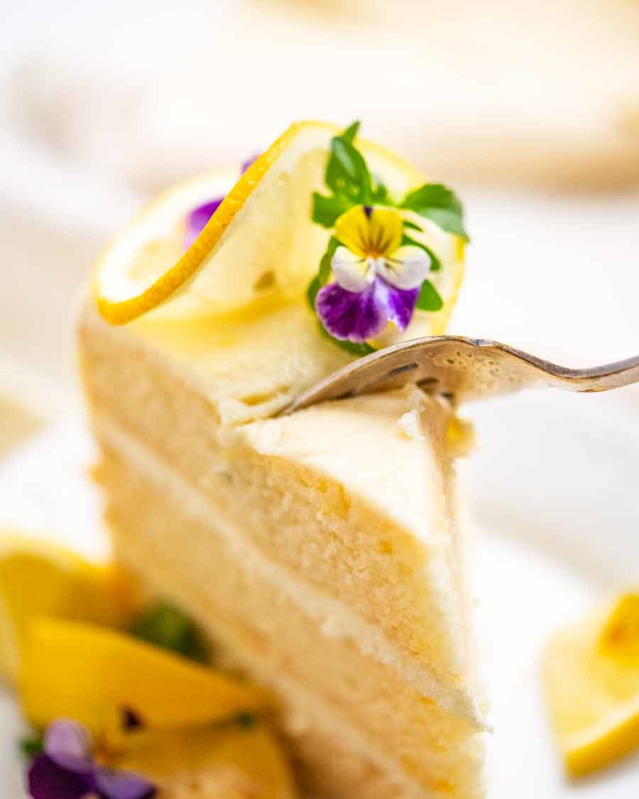 Fork cutting into piece of Lemon Cake with Fluffy Lemon Frosting