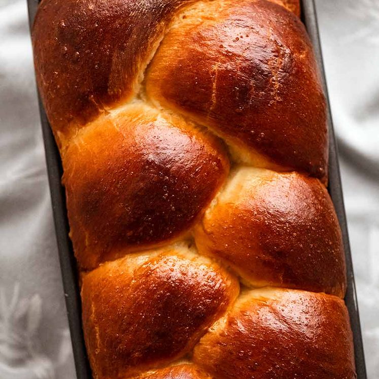 Overhead photo of freshly baked brioche in a loaf pan, fresh out of the oven