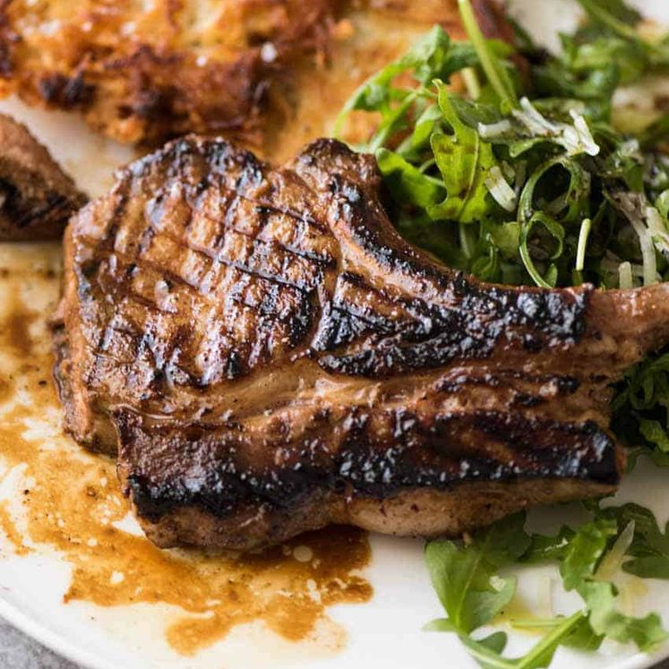 Overhead photo of Grilled chops on a plate with potato rosti and salad, made using amade using a great Pork Chop Marinade