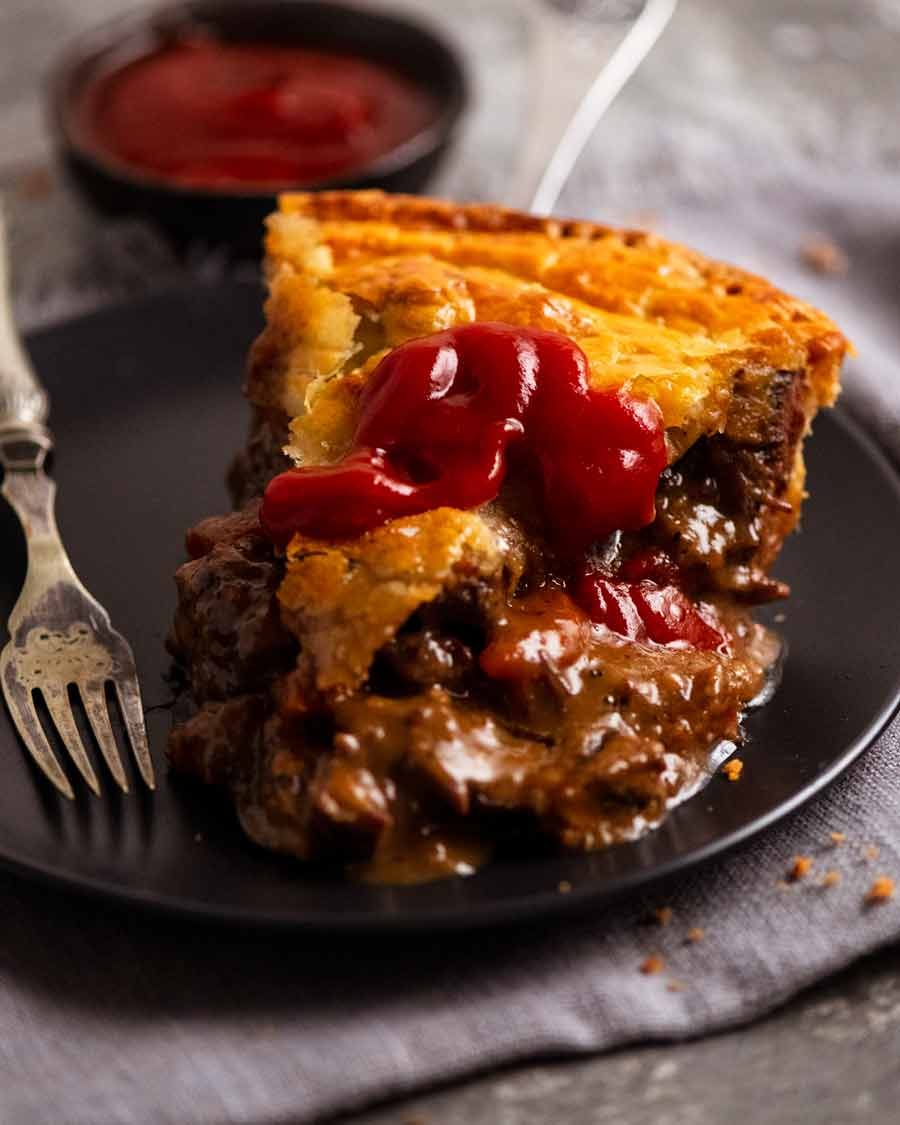 Slice of Family Meat Pie with ketchup on a plate