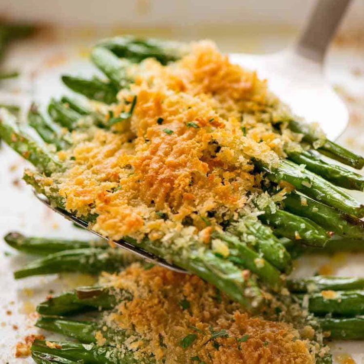 Close up of spatula scooping up Parmesan Roasted Green Beans