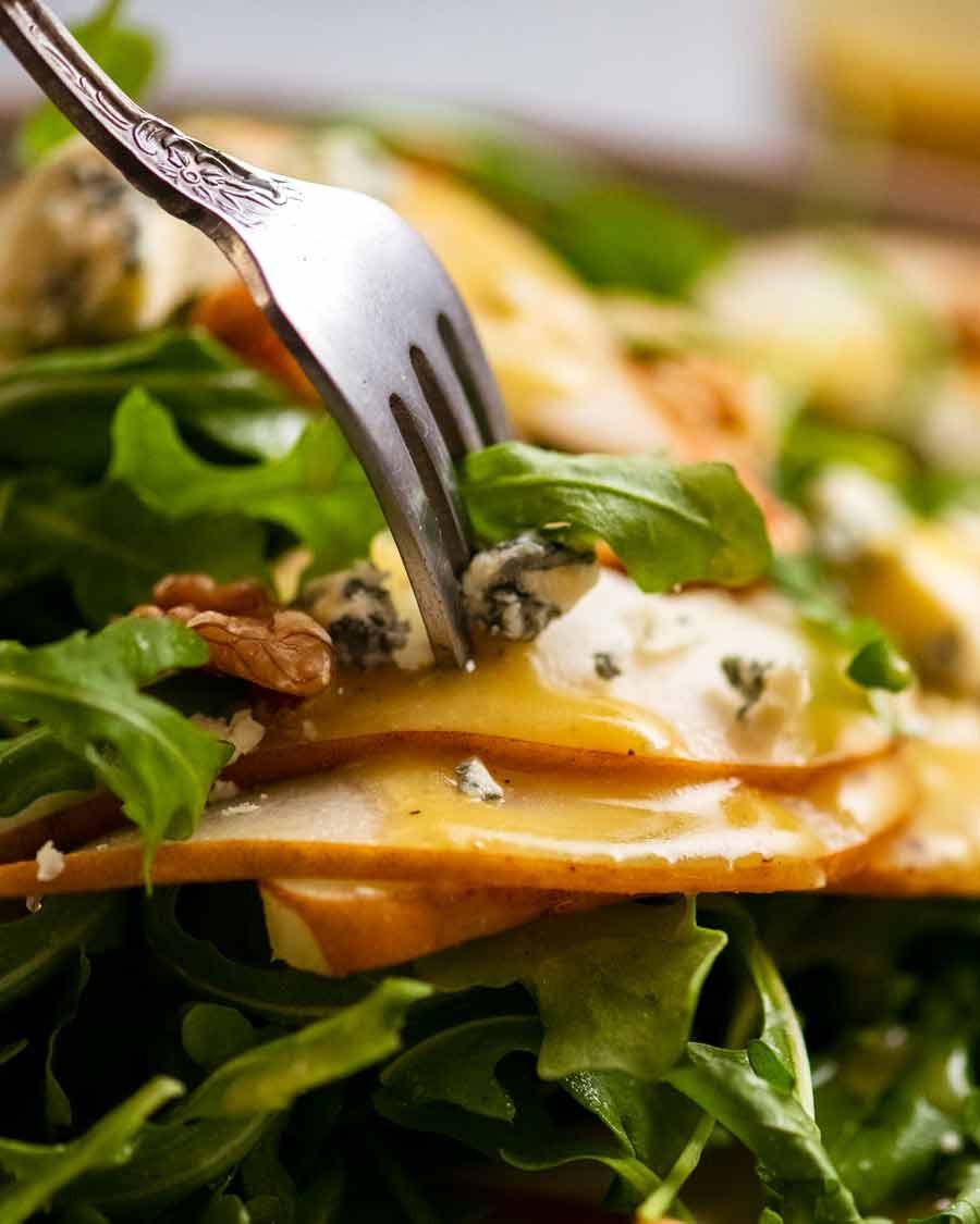 Fork picking up Pear Salad with Blue Cheese and Rocket Arugula