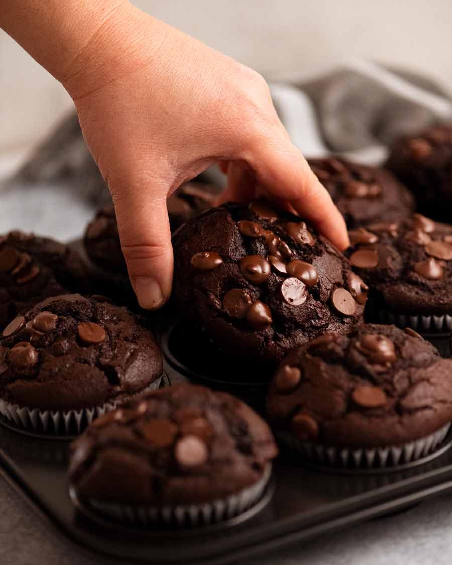 Hand reaching for Chocolate Muffins