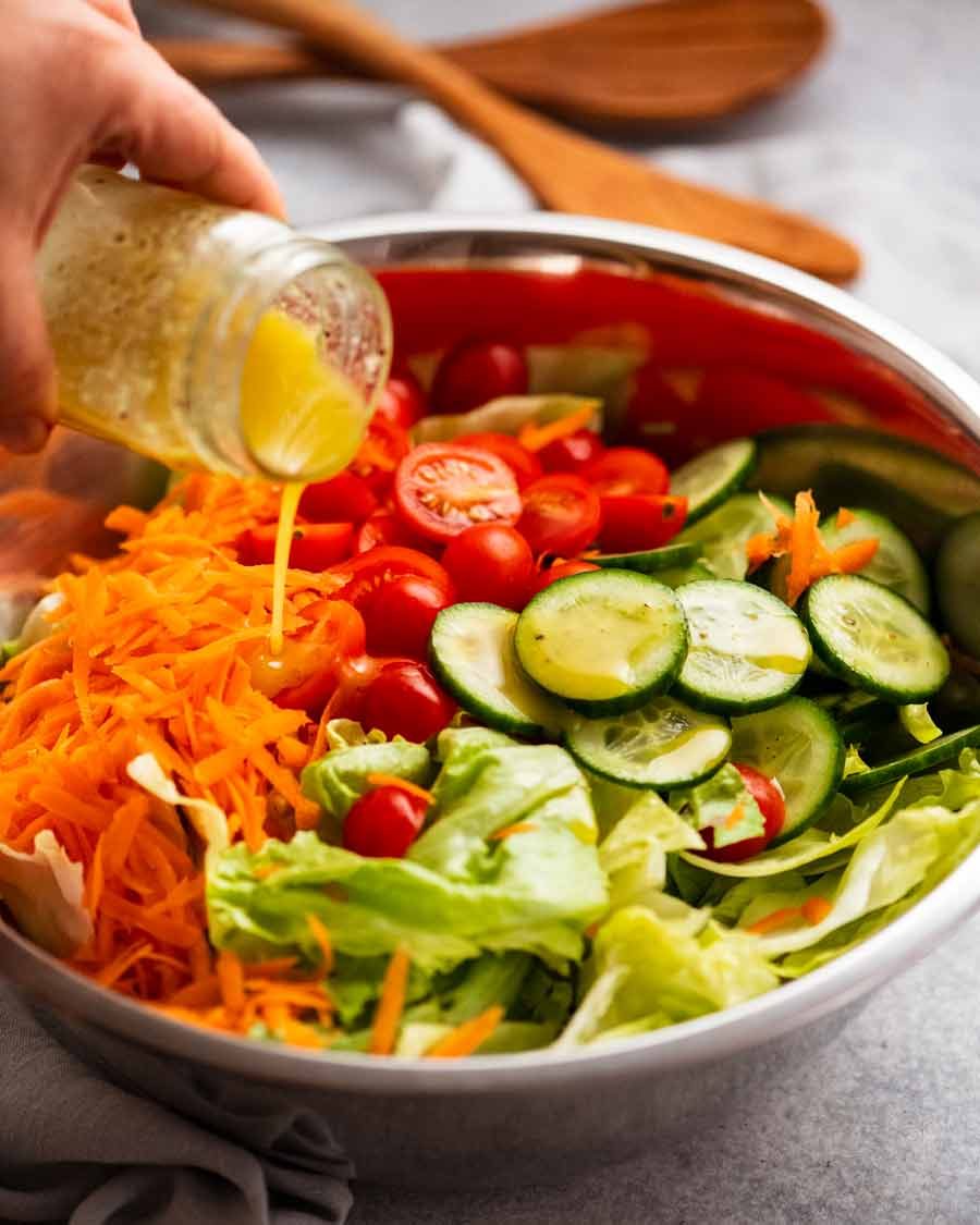 Pouring dressing over Garden salad