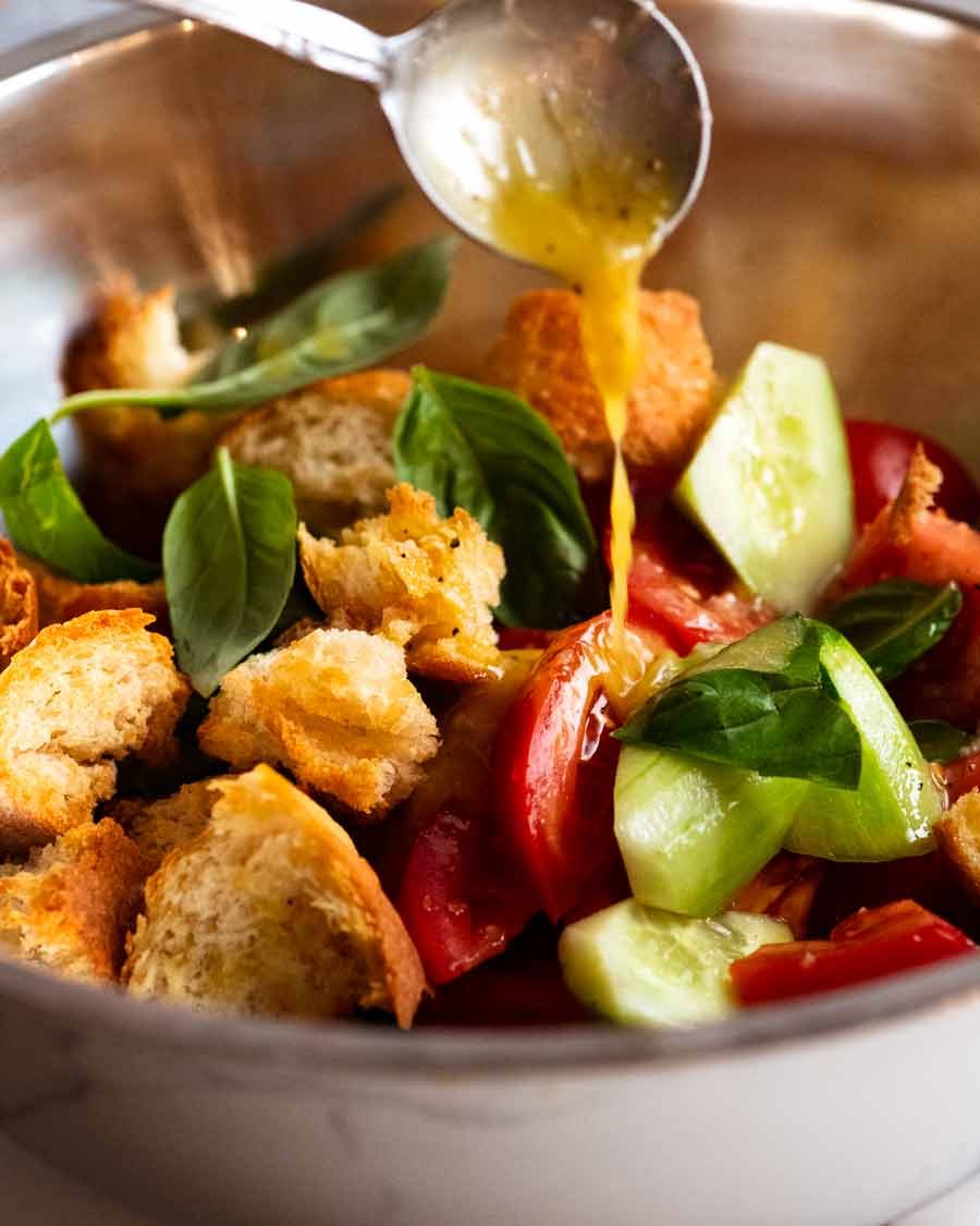 Drizzling dressing over Panzanella - Italian tomato and bread salad