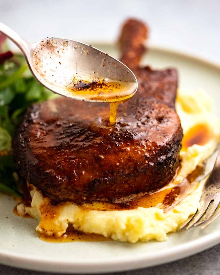 Butter being drizzled on pork cooked with pork rub