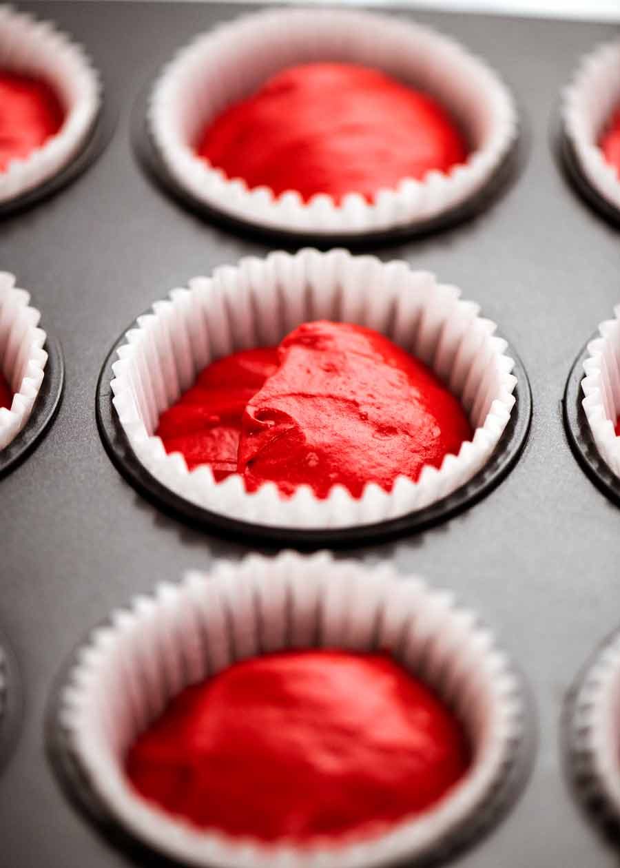 Cupcake liners filled with Red Velvet Cupcake batter ready to be baked