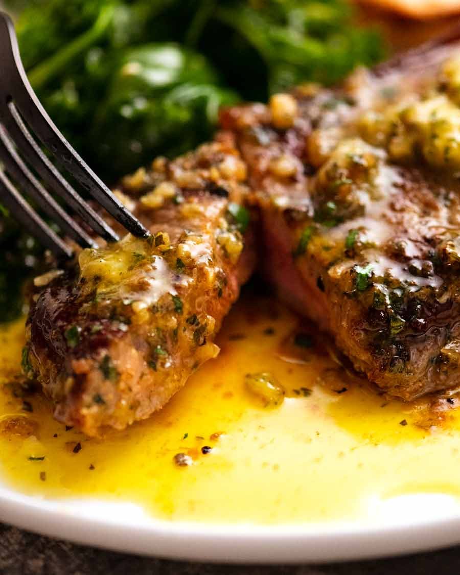 Close up of fork picking up piece of steak with Cafe de Paris butter on steak