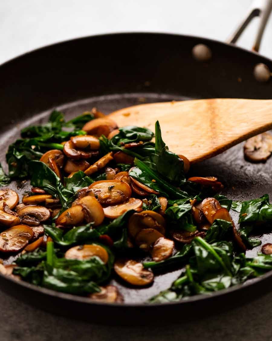 Skillet with sautéed mushrooms and spinach