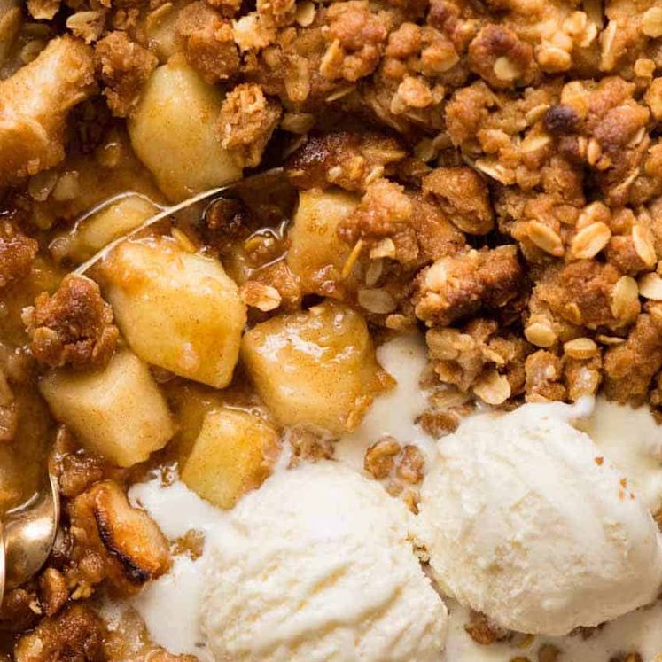 Close up overhead photo of Apple Crumble with scoops of vanilla ice cream