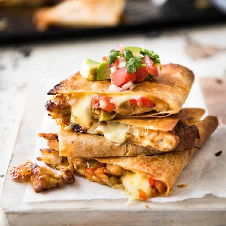 Crispy Oven Baked Chicken Quesadillas - This is how to make multiple Quesadillas at the same time! Crispy on the outside, stuffed with Mexican seasoned chicken and capsicum / bell peppers (and cheese of course!) www.recipetineats.com