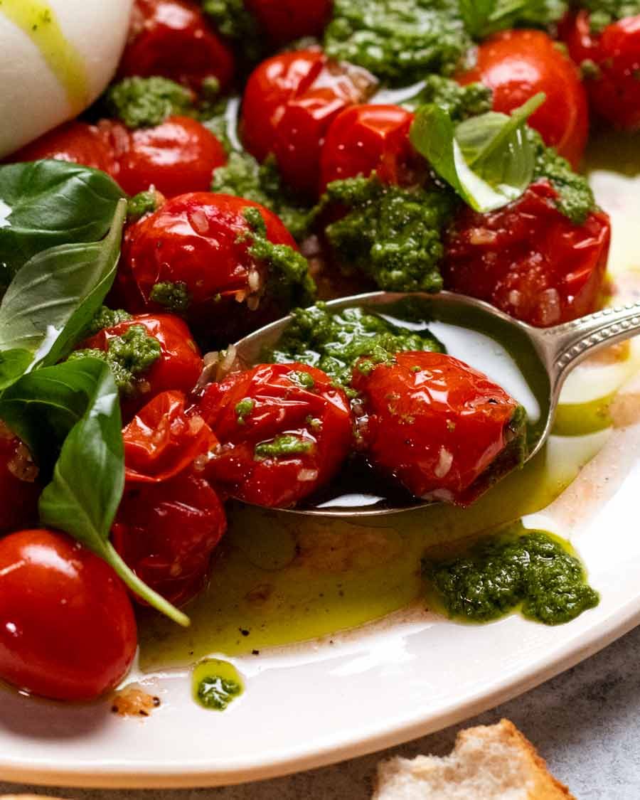 Close up of juicy roast tomatoes in Burst tomato burrata salad