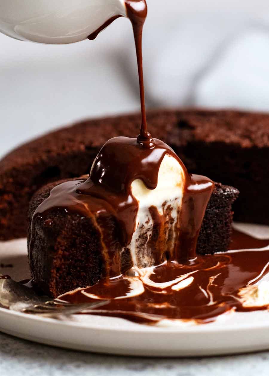 Pouring chocolate sauce over Hot chocolate fudge cake