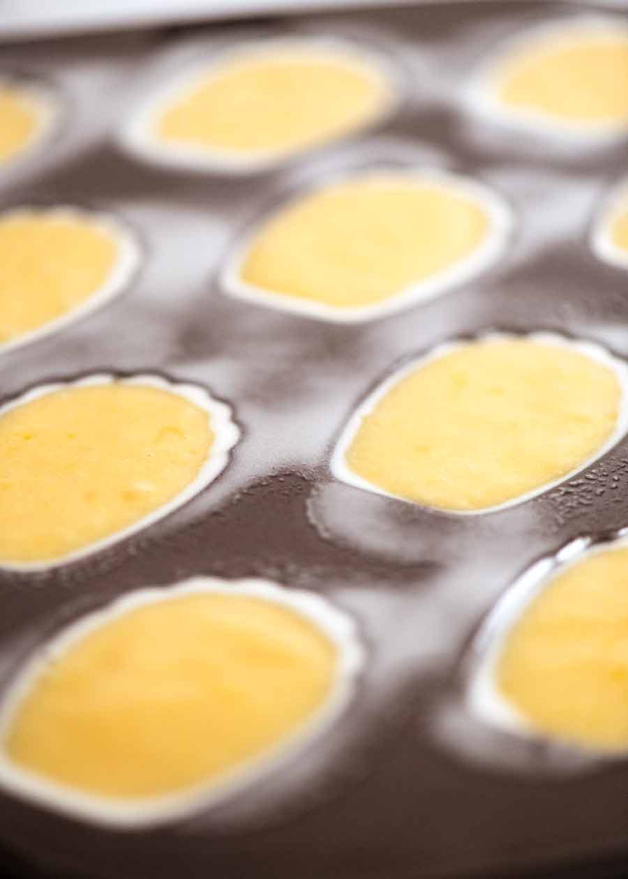 Madeleine pan filled with batter ready to bake