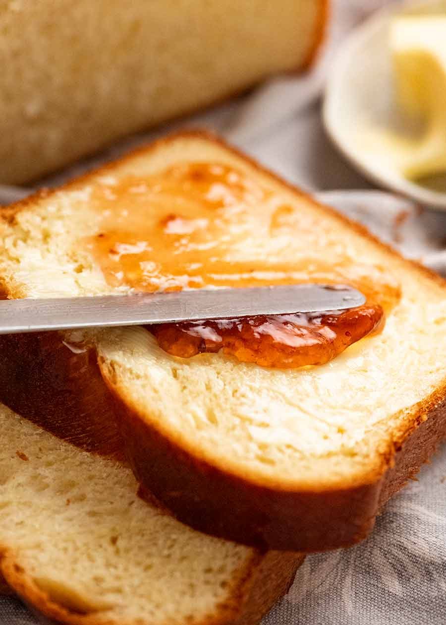 Spreading butter and jam on homemade Brioche