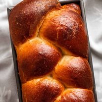 Overhead photo of freshly baked brioche in a loaf pan, fresh out of the oven