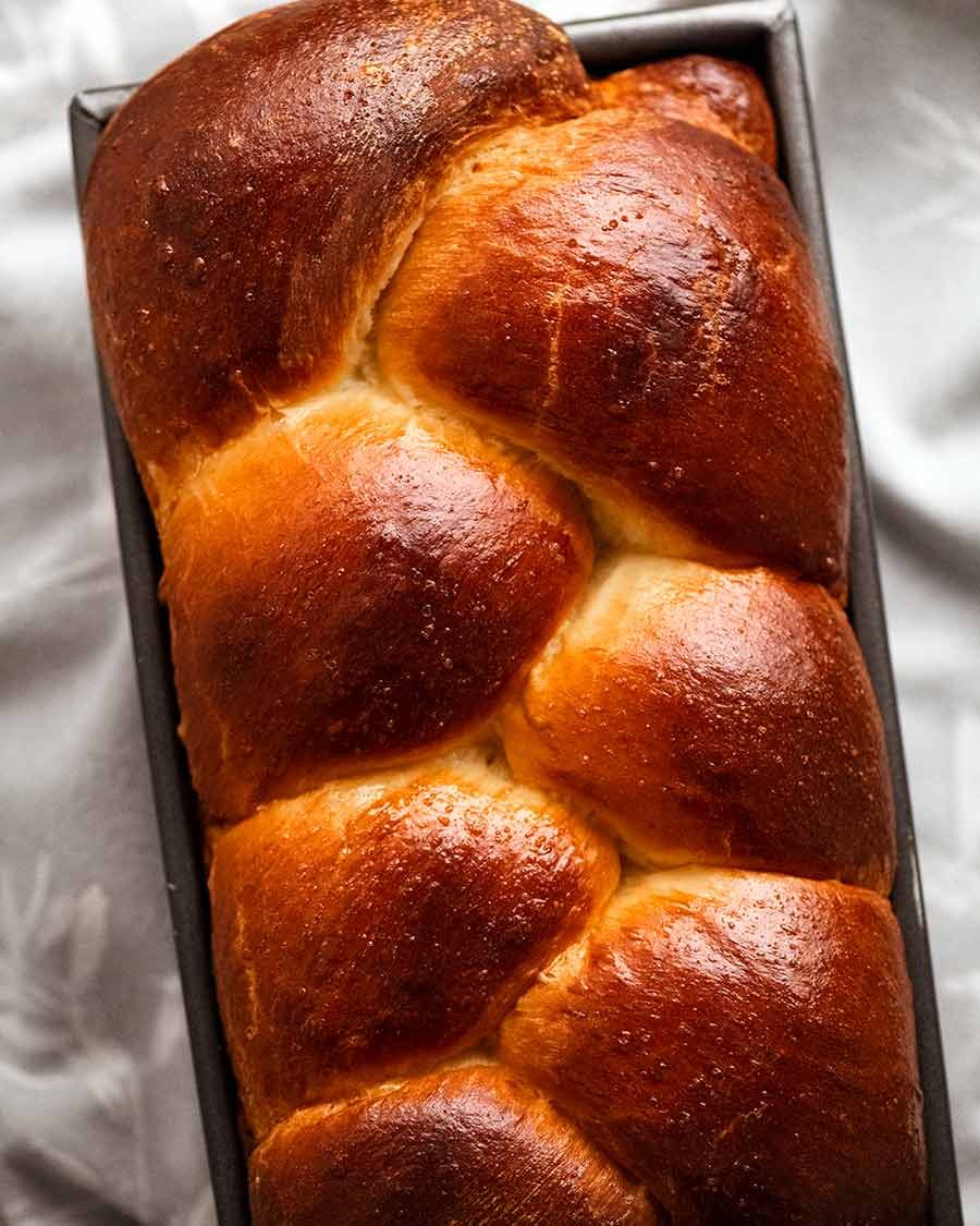 Overhead photo of freshly baked brioche in a loaf pan, fresh out of the oven