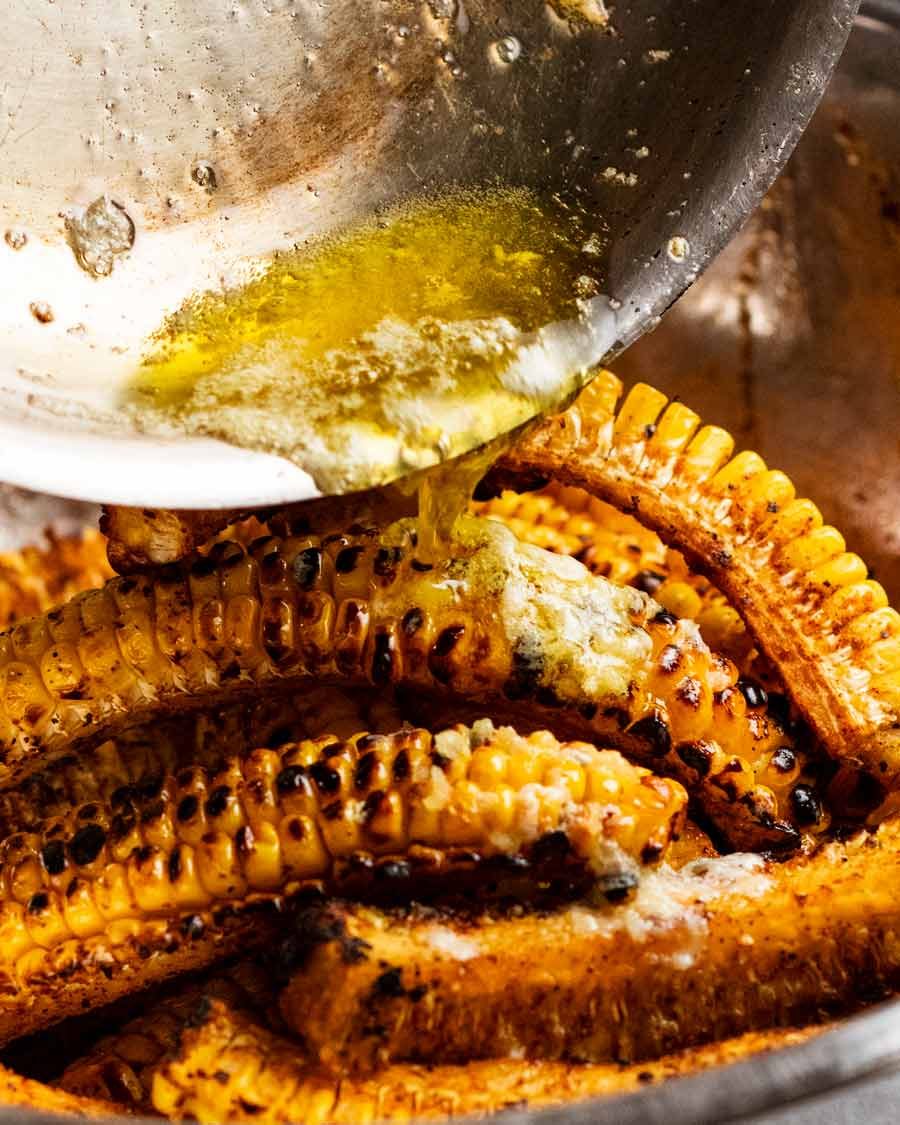 Pouring garlic butter over Corn ribs