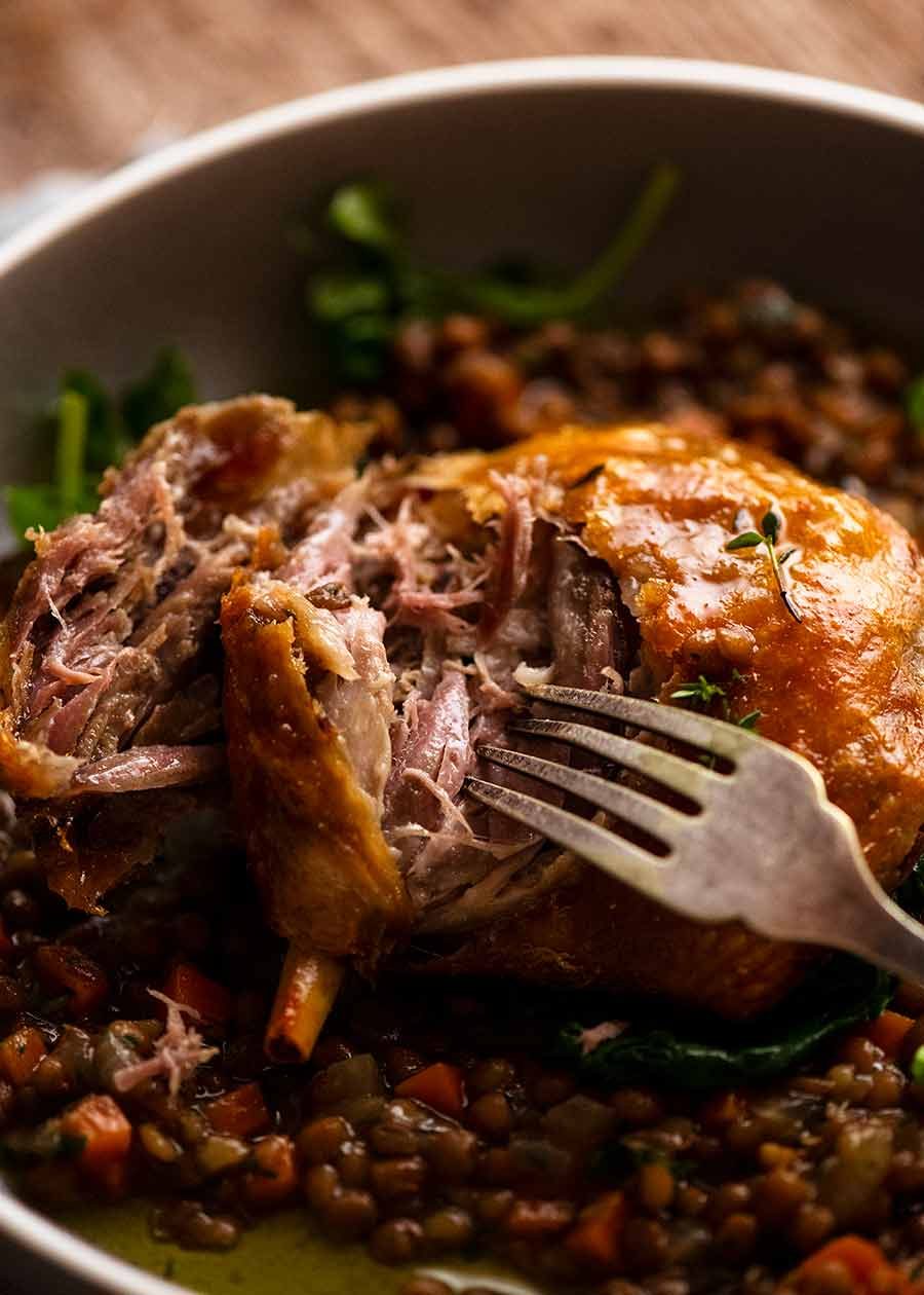 Close up of fork showing tender flesh of Duck Confit