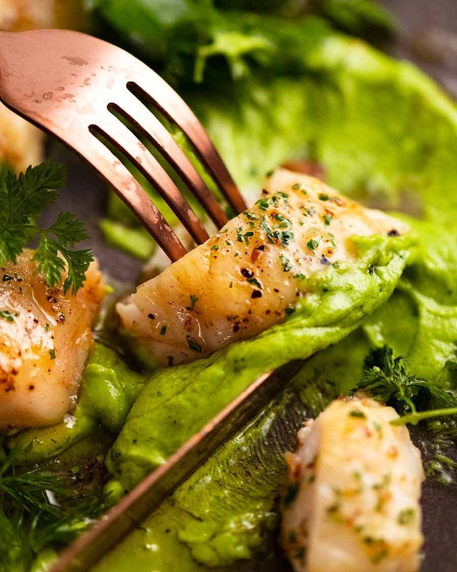 Close up of Monkfish being eaten with pea puree and brown butter