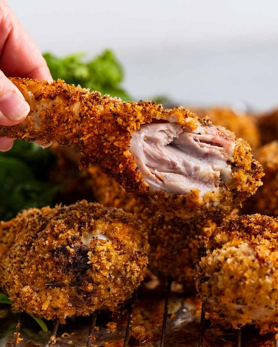 Holding Crunchy crumbed chicken drumsticks