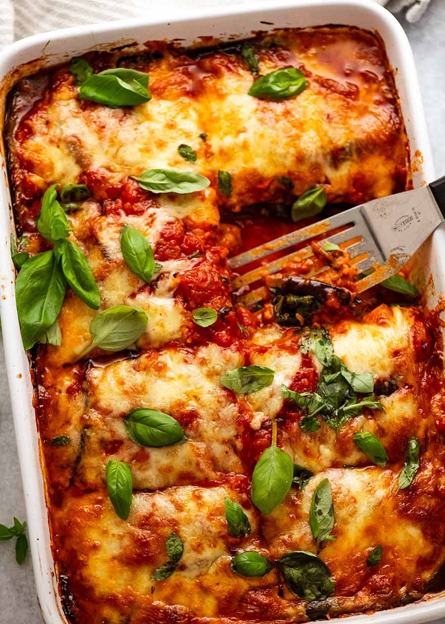 White baking dish with Eggplant Parmigiana, fresh out of the oven