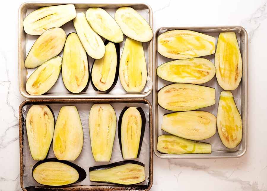 3 trays filled with baked eggplant for Eggplant Parmigiana