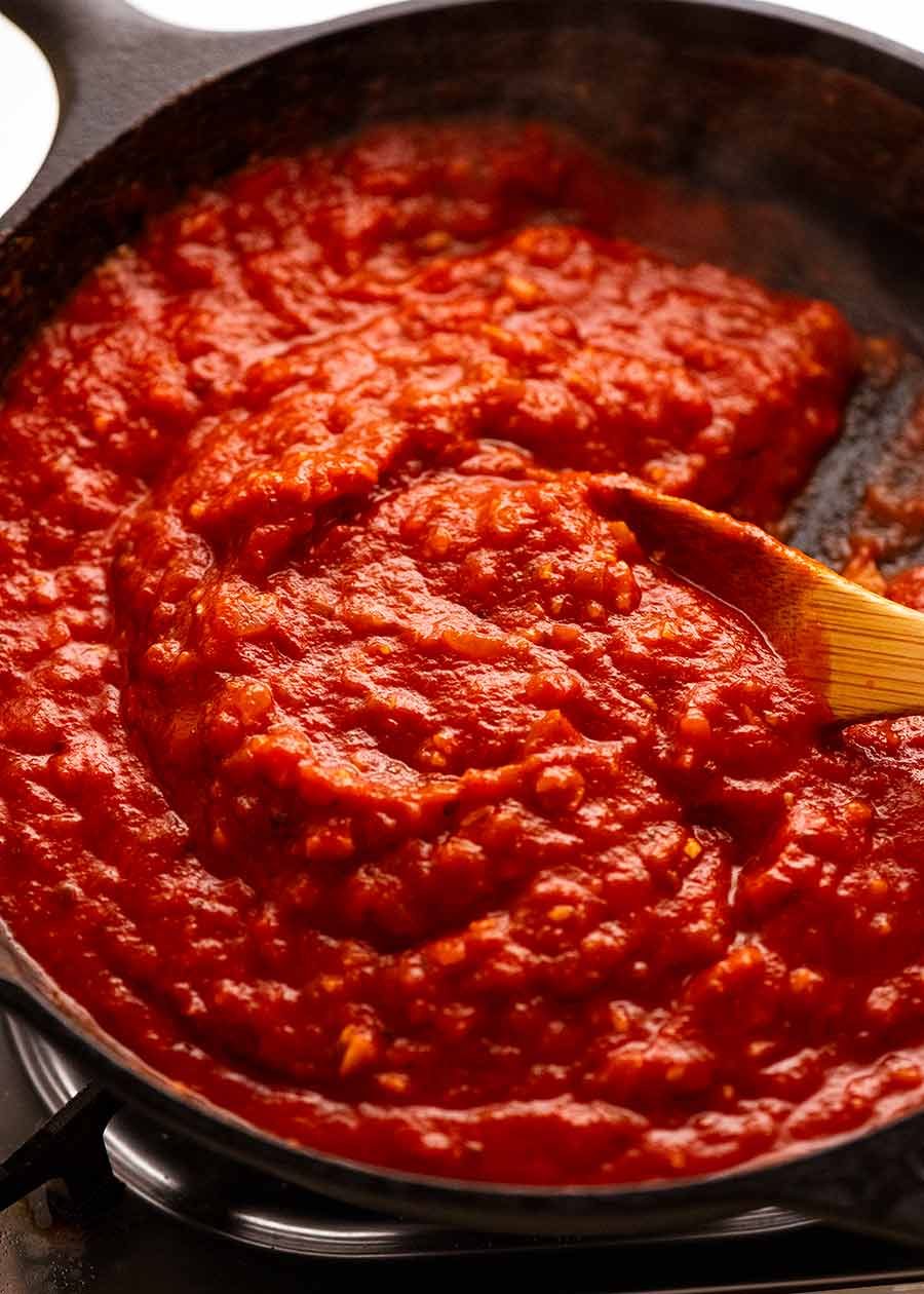 Black skillet fresh off the stove with Eggplant Parmigiana tomato sauce