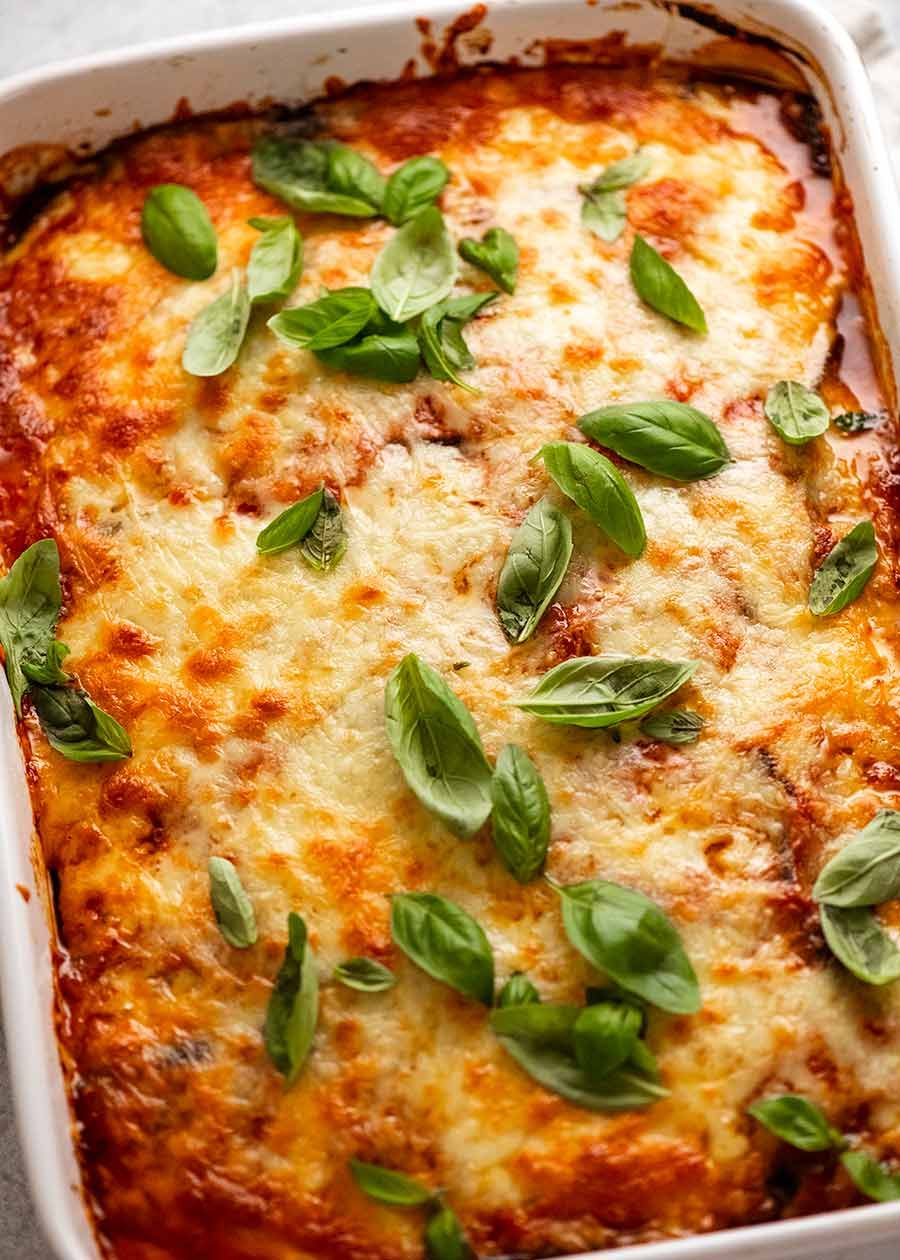 White casserole dish with freshly made Eggplant Parmigiana