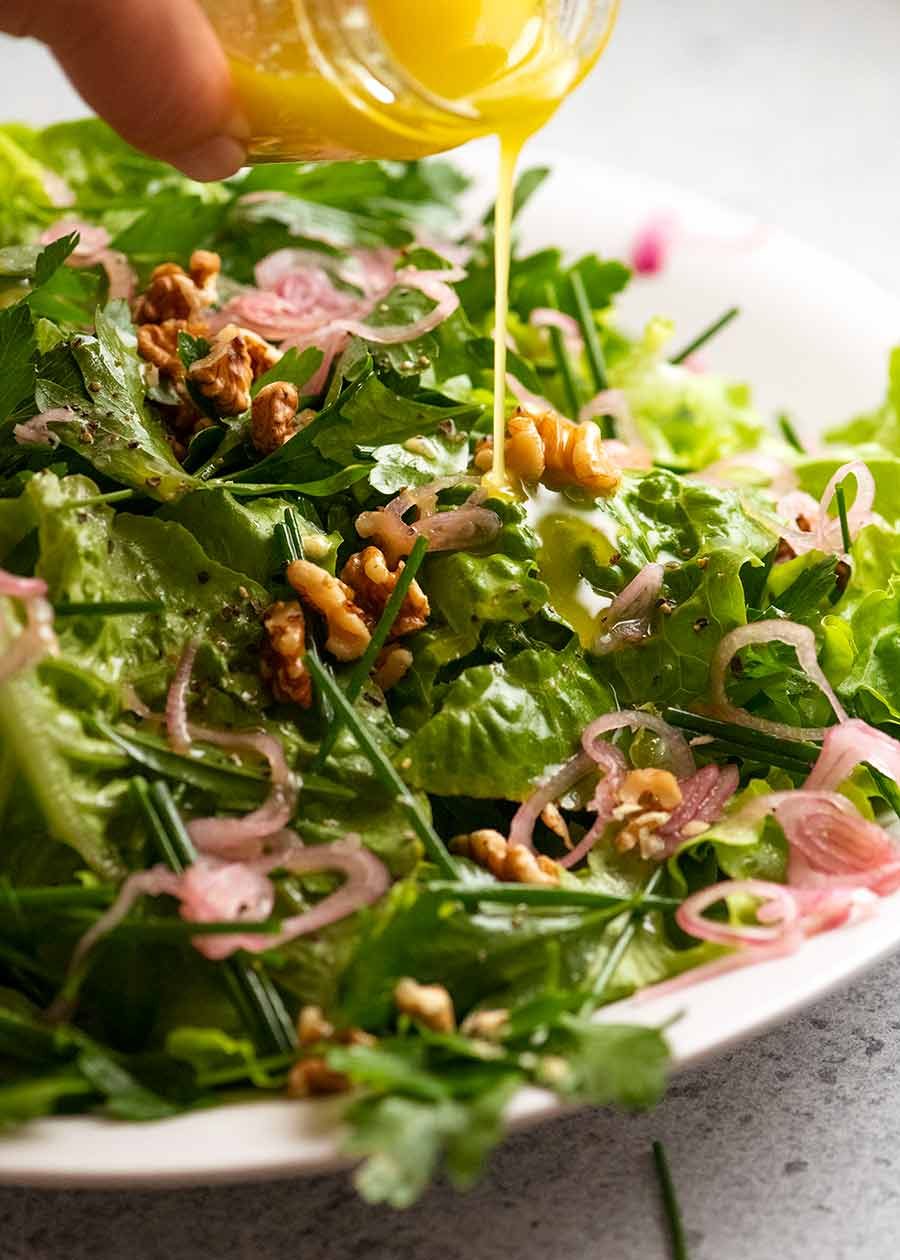 Drizzling lemon dressing over French Bistro Salad