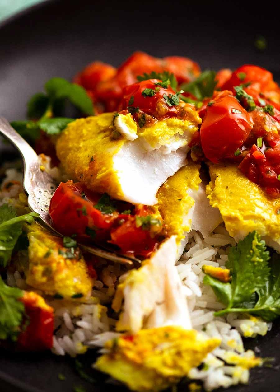 Close up of fork cutting into Golden Turmeric Fish (Indonesian) made with John Dory