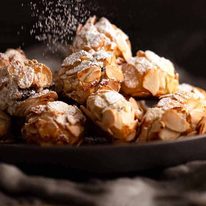 Dusting icing sugar over Italian Almond Cookies