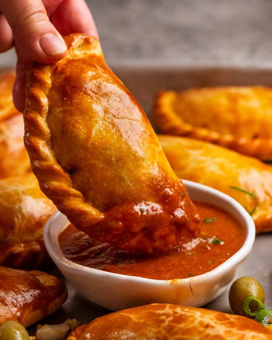 Dipping Beef empanada in sauce