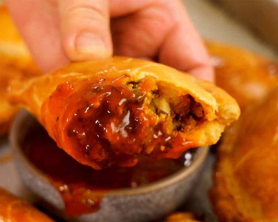 Dipping empanada in Empanada sauce