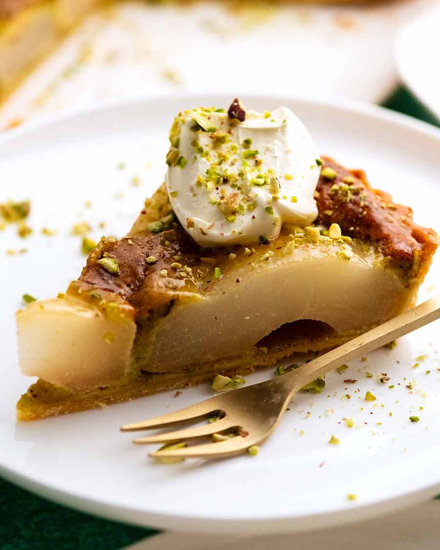 Slice of Pistachio Pear Tart on a white plate, ready to be eaten