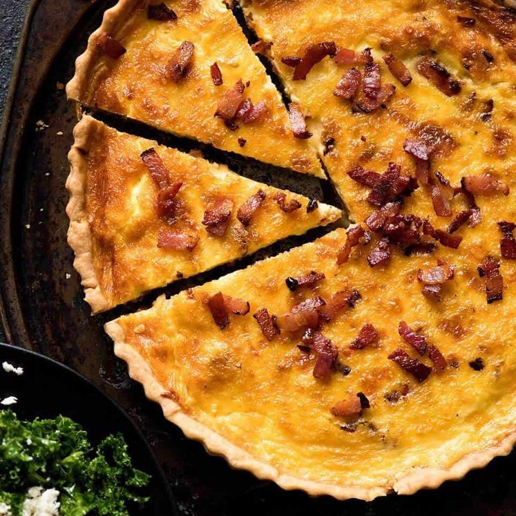 Overhead photo of a golden Quiche Lorraine with 2 pieces cut