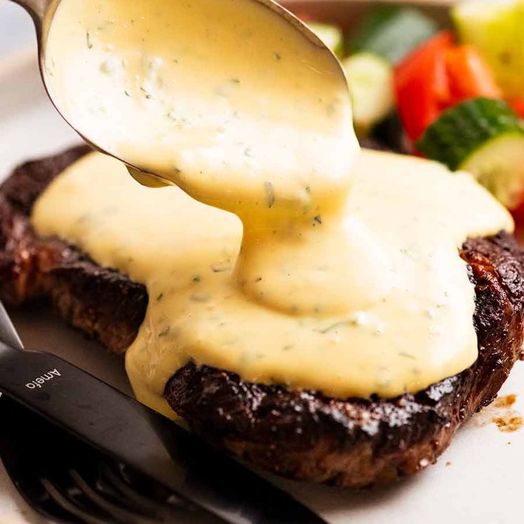 Spooning Bearnaise Sauce over steak