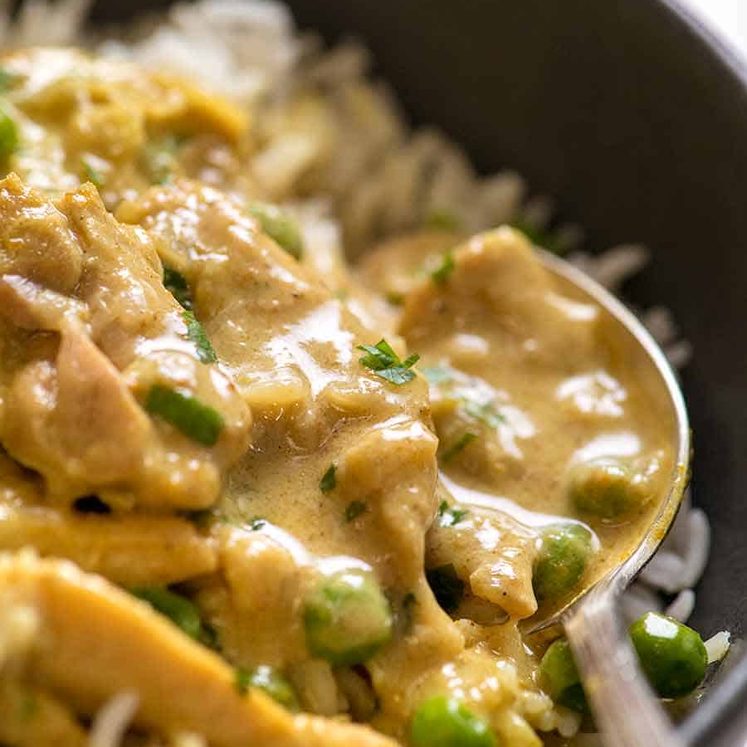 Close up of easy Chicken Curry served over rice in a rustic black bowl.