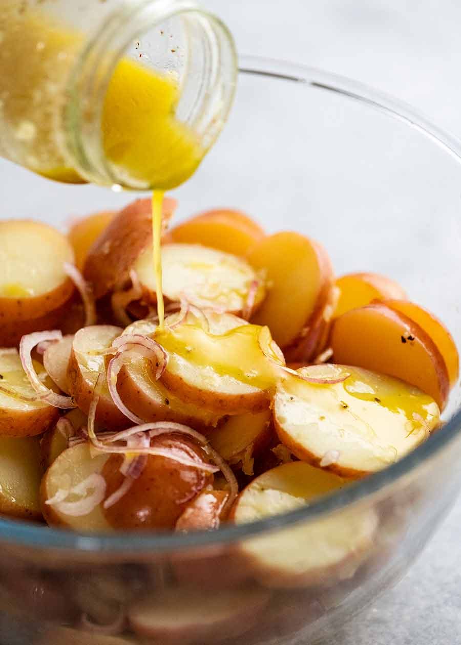 Pouring dressing over Red Potato Salad