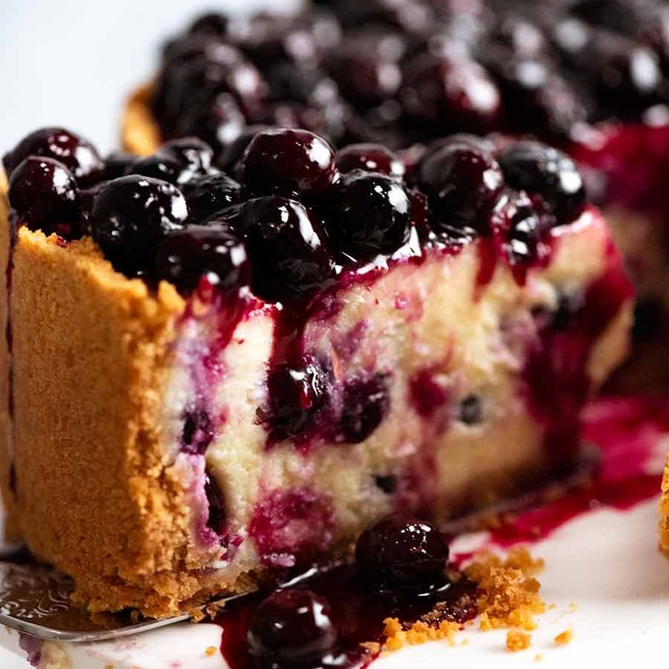 Close up of slice of Blueberry Cheesecake with drip of Blueberry Sauce