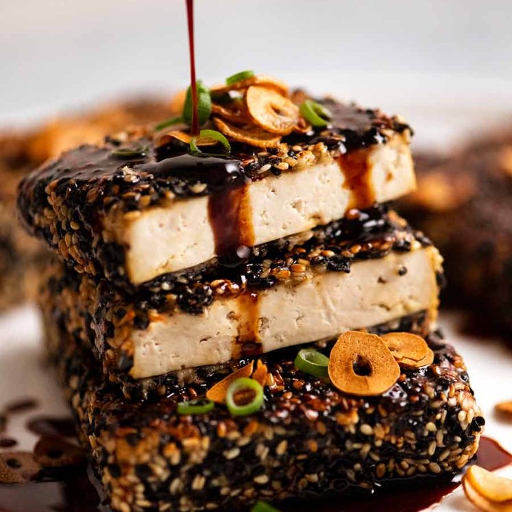 Drizzling Teriyaki Sauce over Sesame crusted Tofu Steaks with Teriyaki Sauce