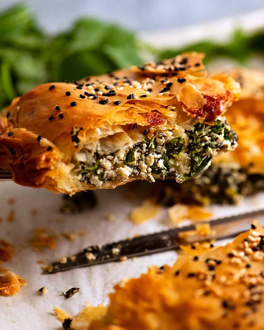 Close up lifting up a slice of Spanakopita