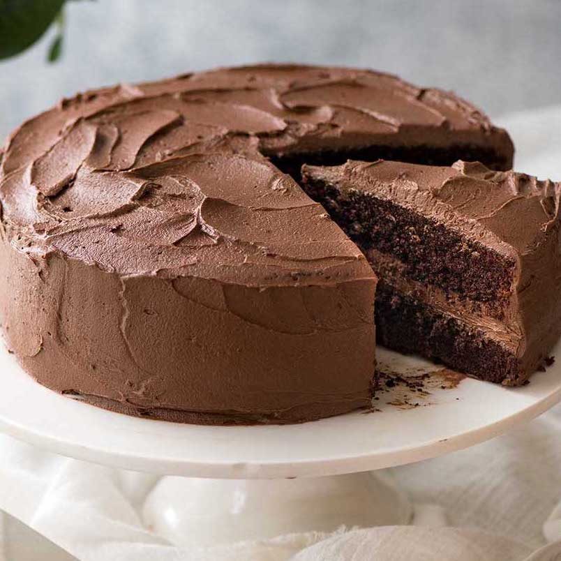 chocolate-cake_9-sq Chocolate Cake with buttercream frosting on a white cake stand, ready to be cut and served