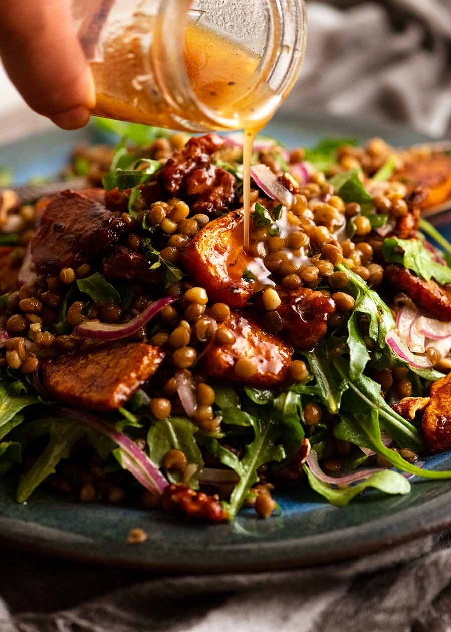 honey-cinnamon-pumpkin-lentil-salad_9 Pouring dressing over Honey Cinnamon Pumpkin Lentil Salad
