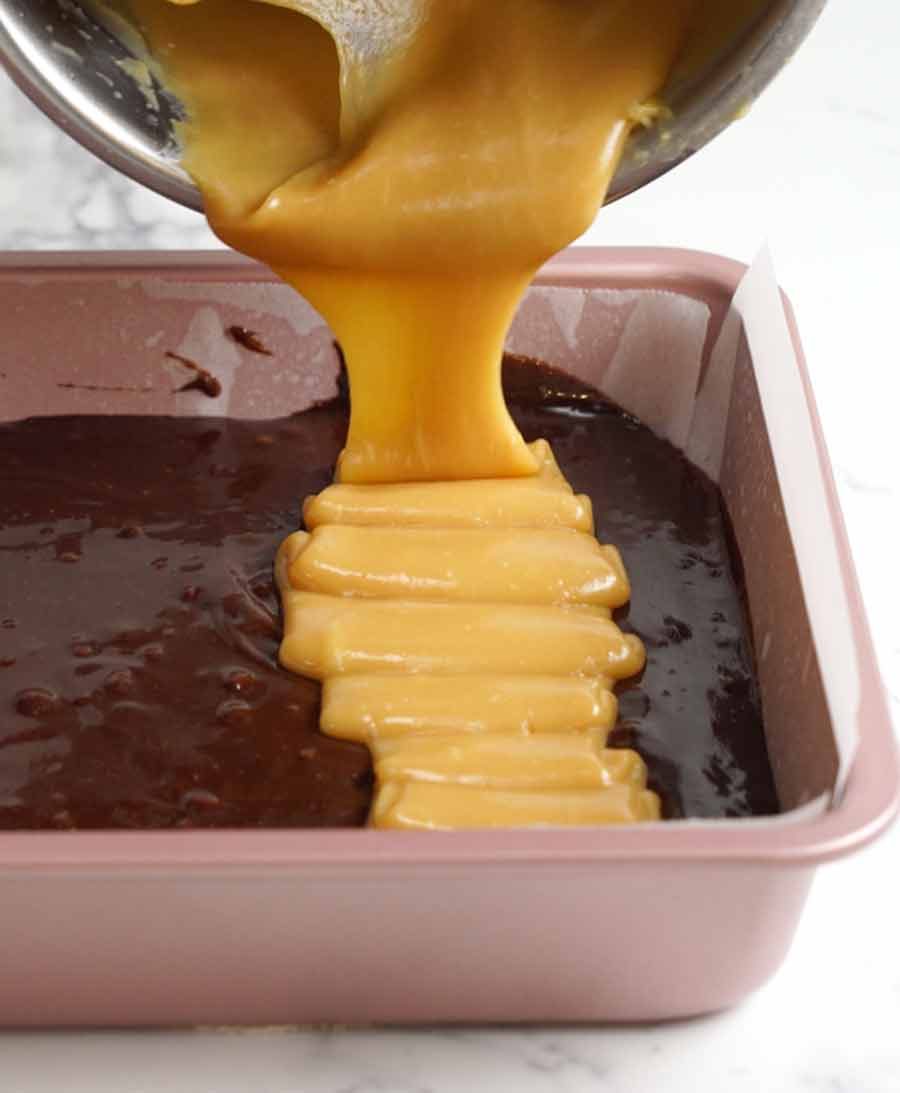 salted-caramel-being-poured-over-brownie Pouring caramel over brownies
