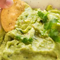 guacamole_6-sq Corn chip scooping up guacamole