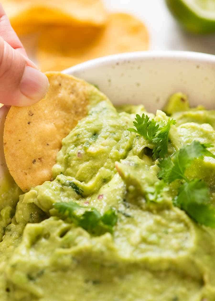 guacamole_6 Close up of corn chip being dipped into Guacamole