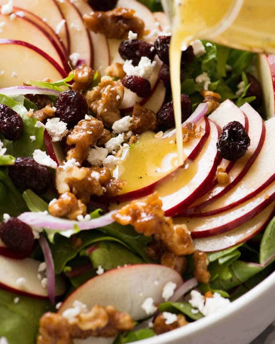 apple-salad-with-candied-walnuts-cranberries_3-2-1 Vinaigrette being poured over Apple Salad with Candied Walnuts and Cranberries